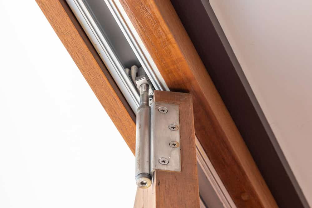 Close-up of a wooden sliding door hinge mechanism.