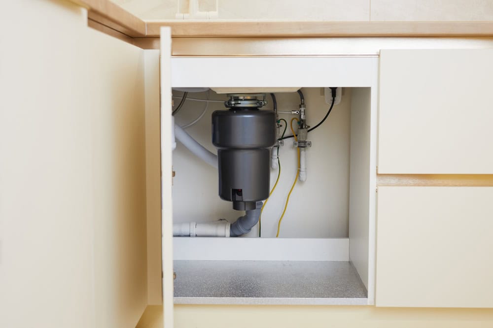 Modern garbage disposal unit installed under a kitchen sink.