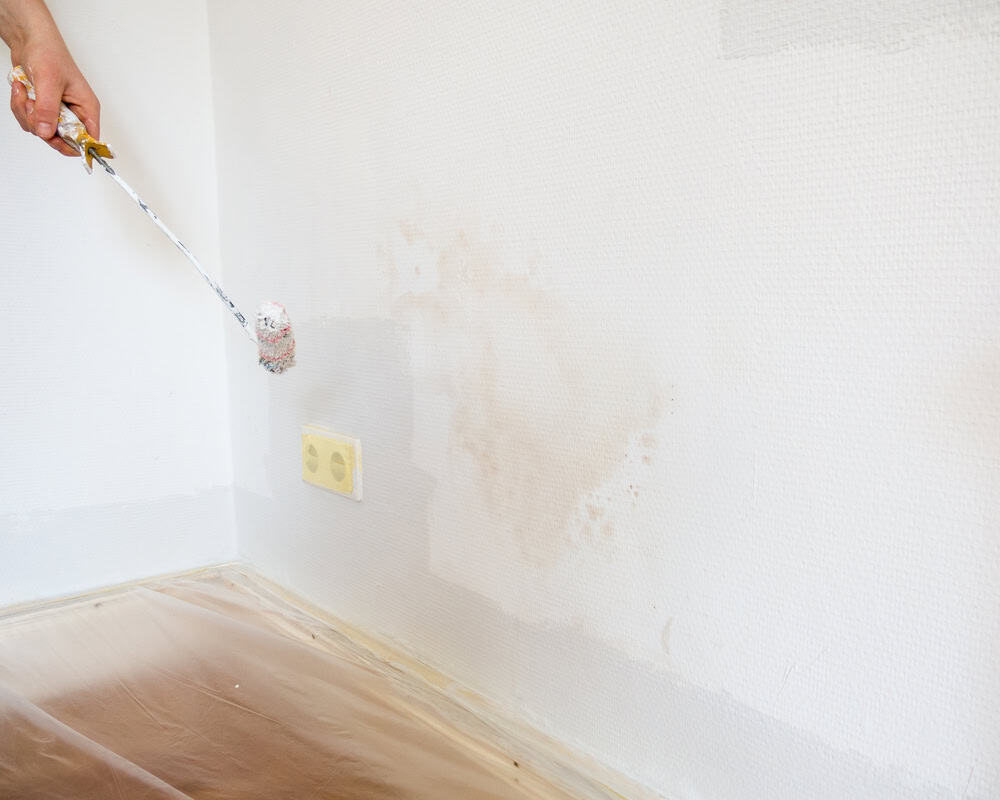 Painting over water-damaged wall stains.