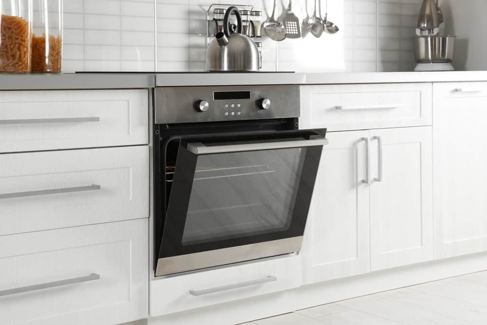 A modern kitchen featuring a sleek stainless steel oven with a glass door.