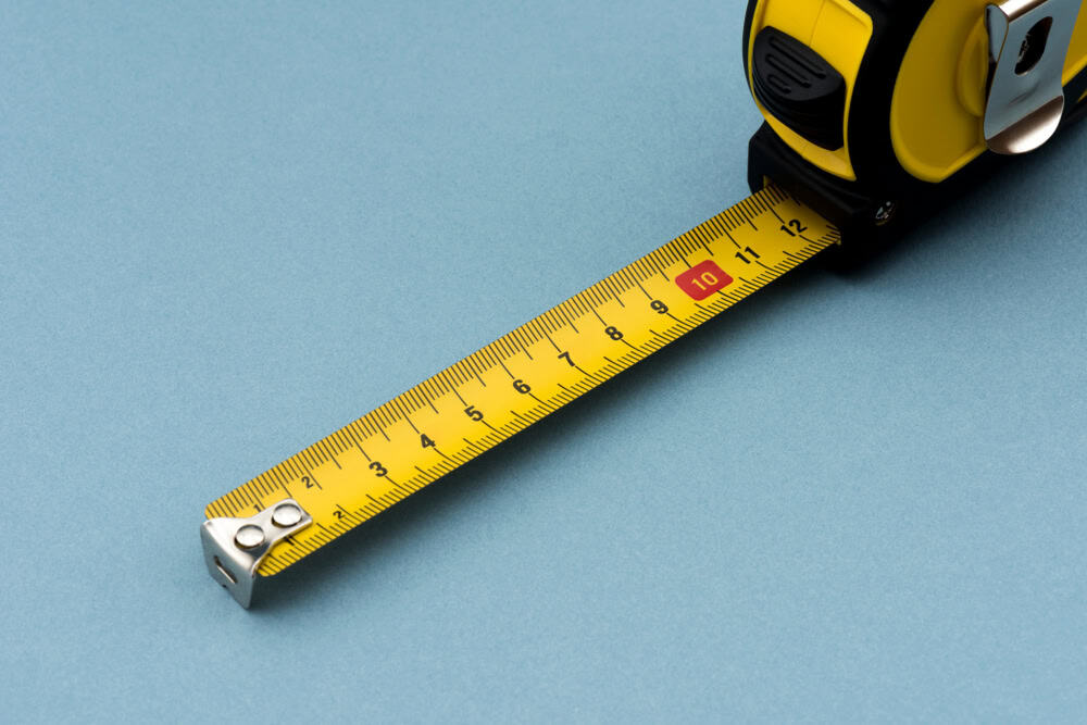 A yellow tape measure extends across a blue surface, ready for precise measurements.
