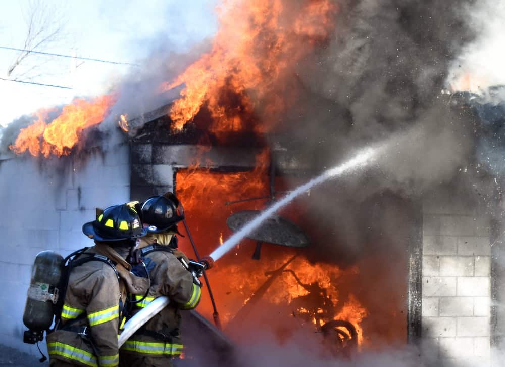 Firefighters battle intense flames engulfing a garage.