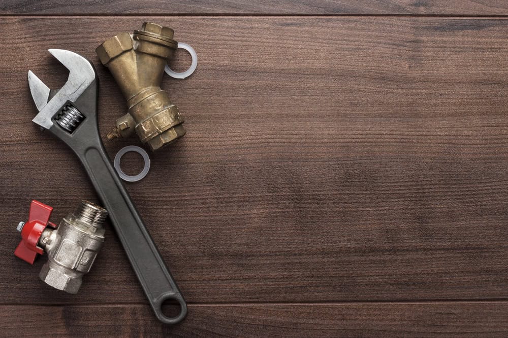 A wrench and plumbing fittings on a wooden surface, ready for a DIY project.
