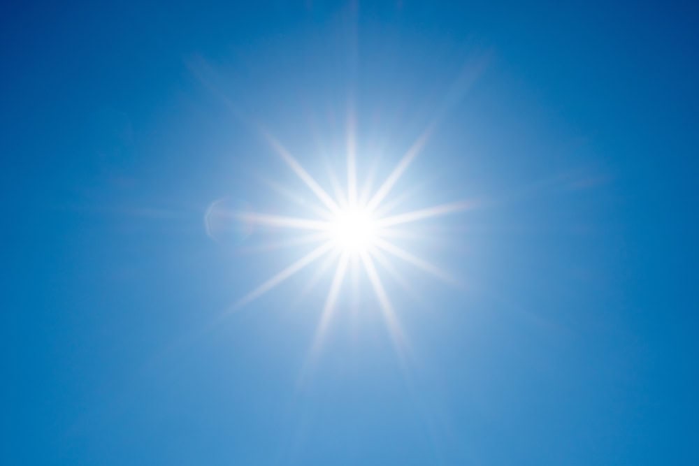 Blazing sun in a cloudless blue sky