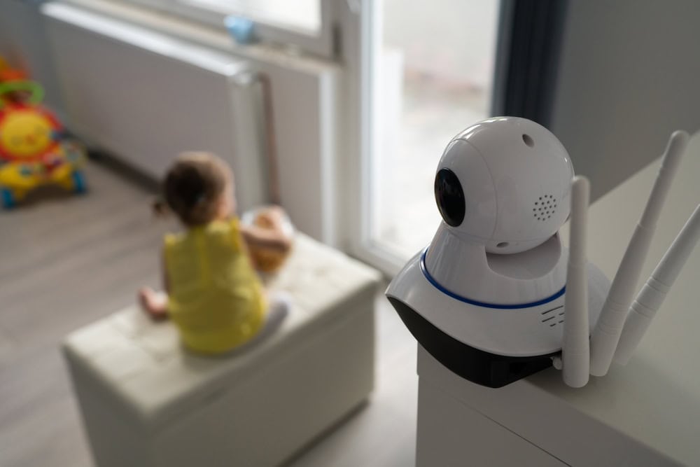A child plays in the background while a security camera keeps watch.