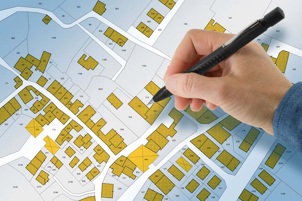 A detailed urban map is being meticulously marked with a pen.