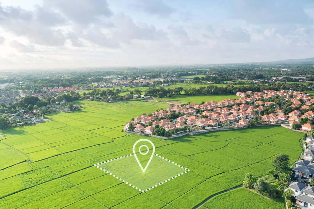 A serene suburban landscape with lush green fields and a growing community of homes.