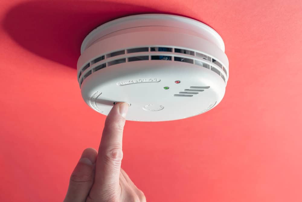 Testing the smoke detector for safety and peace of mind.