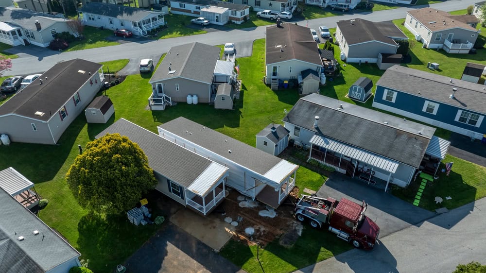 A mobile home is delivered to a quiet suburban neighborhood.