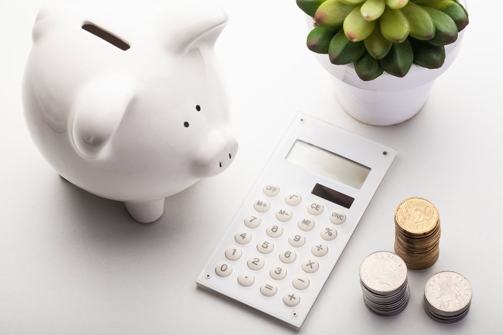 Piggy bank, calculator, and coins ready for budgeting success.