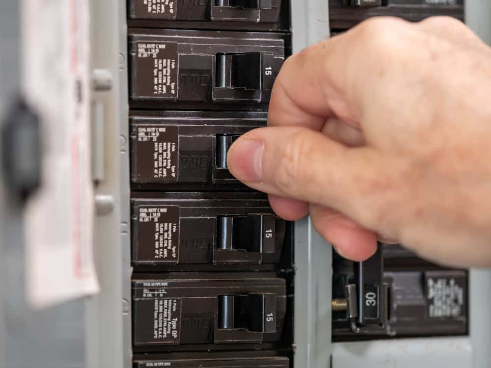 Resetting a tripped circuit breaker to restore power in the electrical panel.