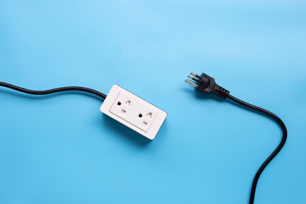 A lone power strip and a plug, disconnected yet ready to connect.