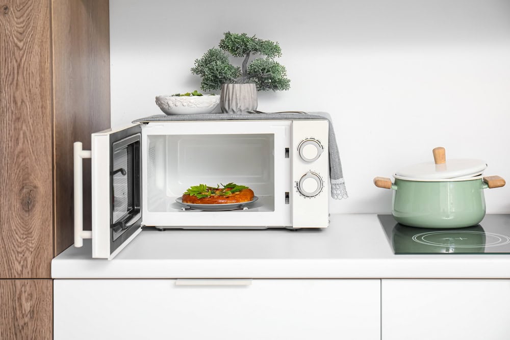 A cozy kitchen scene featuring a microwave with a freshly baked dish.