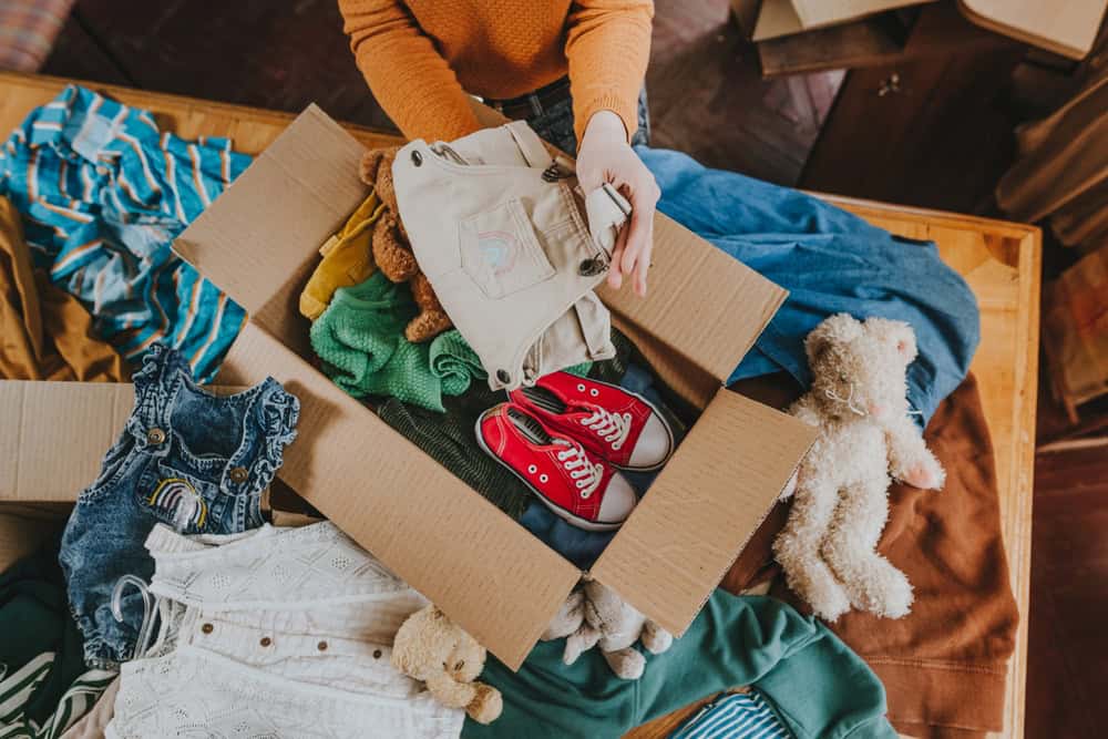 Packing up memories: children's clothes, toys, and tiny red sneakers ready for donation