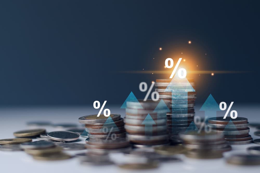Stacks of coins with glowing percentage symbols and upward arrows.