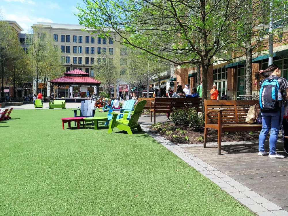 Vibrant outdoor seating area with colorful Adirondack chairs and benches.