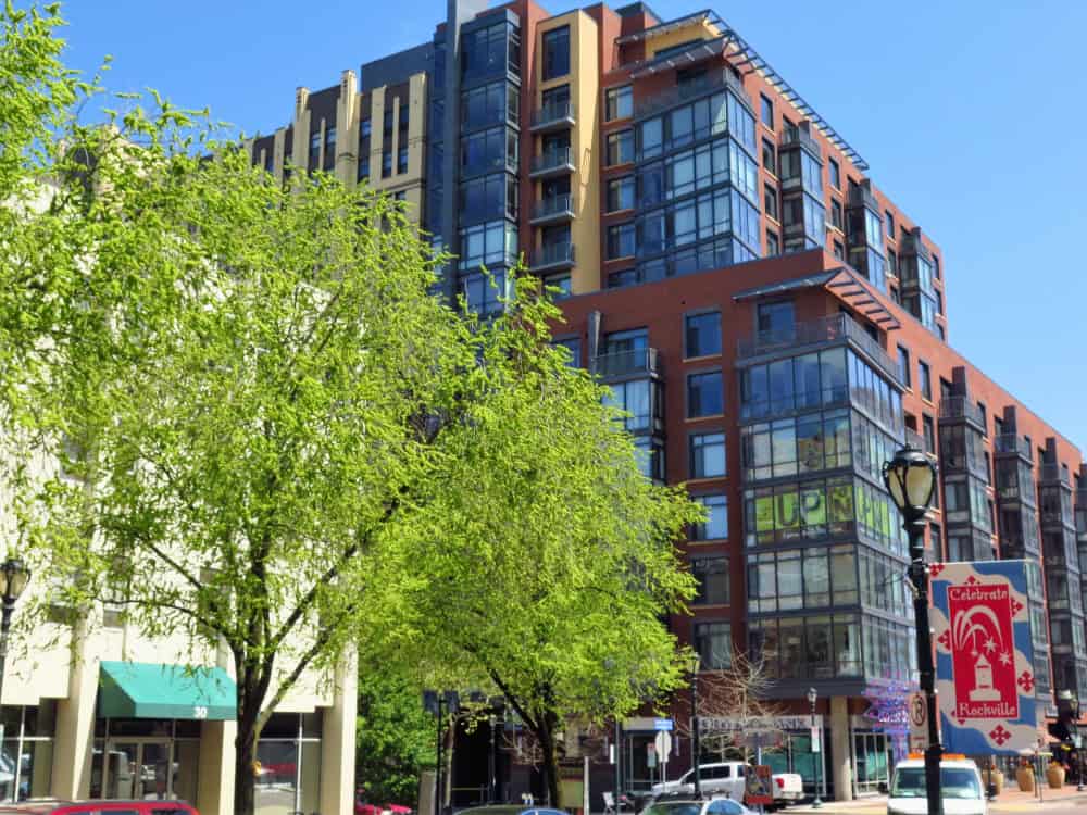 Modern urban living in Rockville, Maryland, surrounded by lush greenery and vibrant street life.