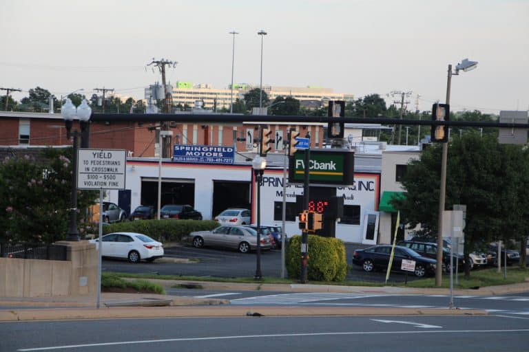 A quiet street in Springfield, VA, with a yield sign, traffic lights, and local businesses like Springfield Motors and a bank.