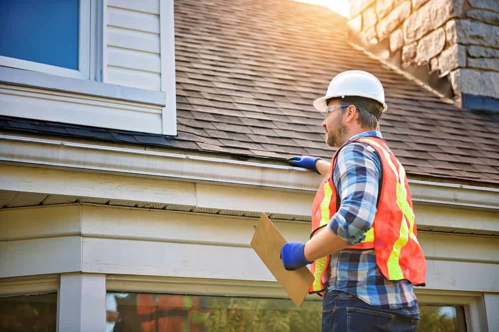 Home inspector assessing potential roof damage.