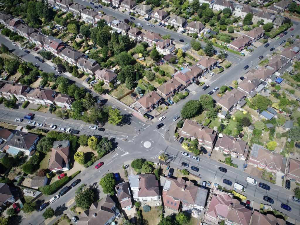 A picturesque aerial view of a suburban neighborhood and its tidy streets converging at a charming roundabout.