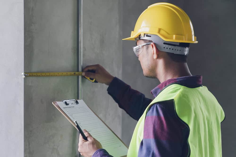 Precision in progress: A construction inspector carefully measures for quality and accuracy.
