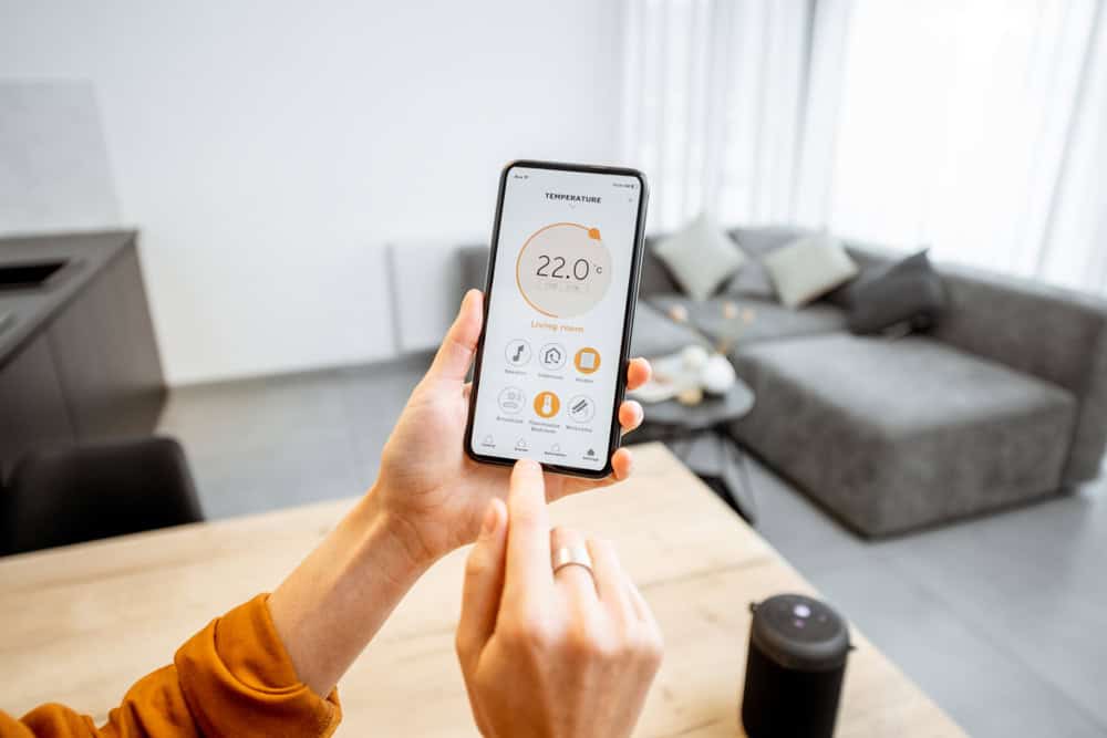 Adjusting the smart home thermostat with ease, enjoying the comfort of a modern living space.