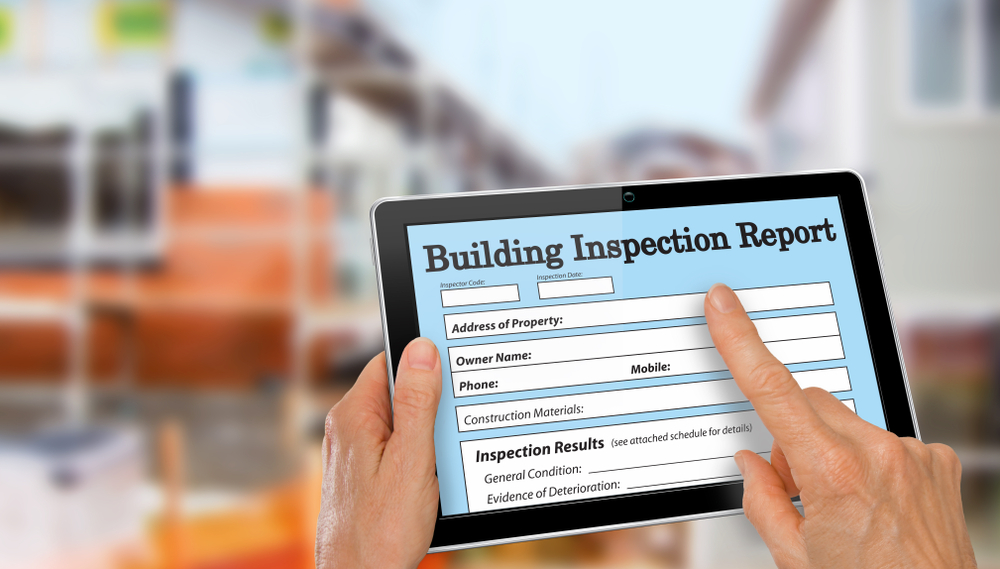 A tablet displaying a building inspection report, highlighting essential property details.