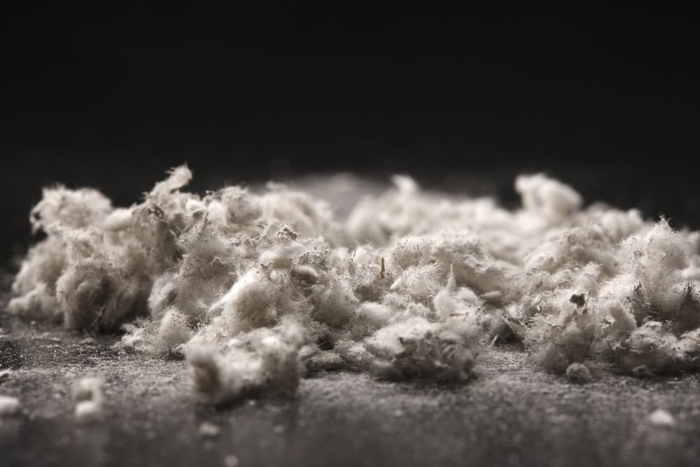 A pile of fluffy, raw cotton against a dark background.