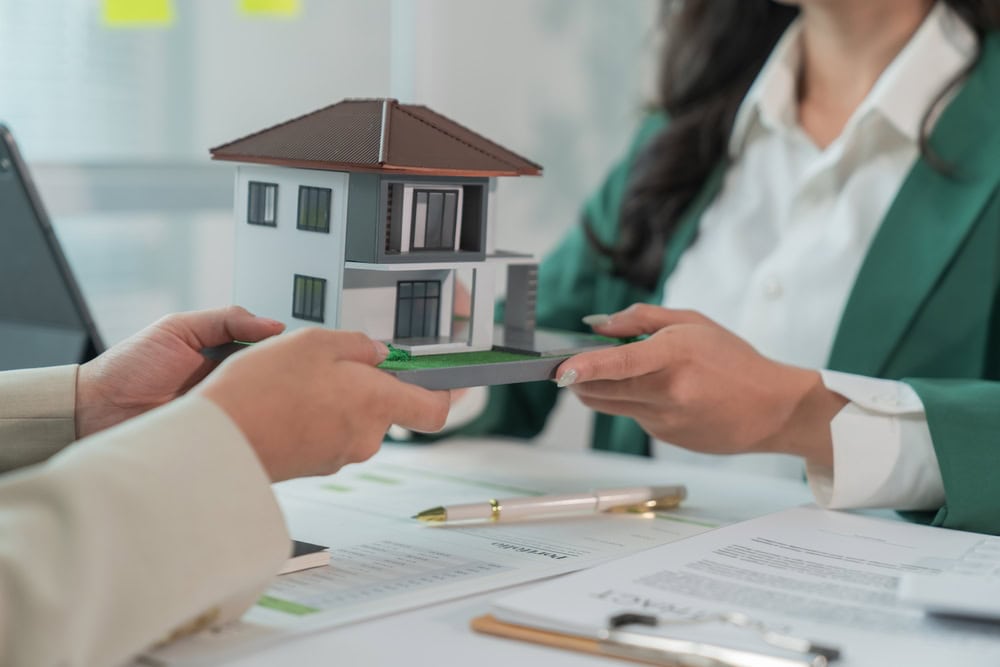 Handing over the keys to a new home: a model house symbolizes the dream of homeownership.