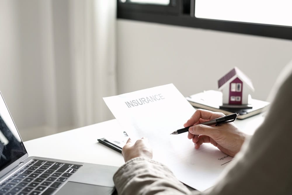 Signing insurance documents with a focus on securing the future.