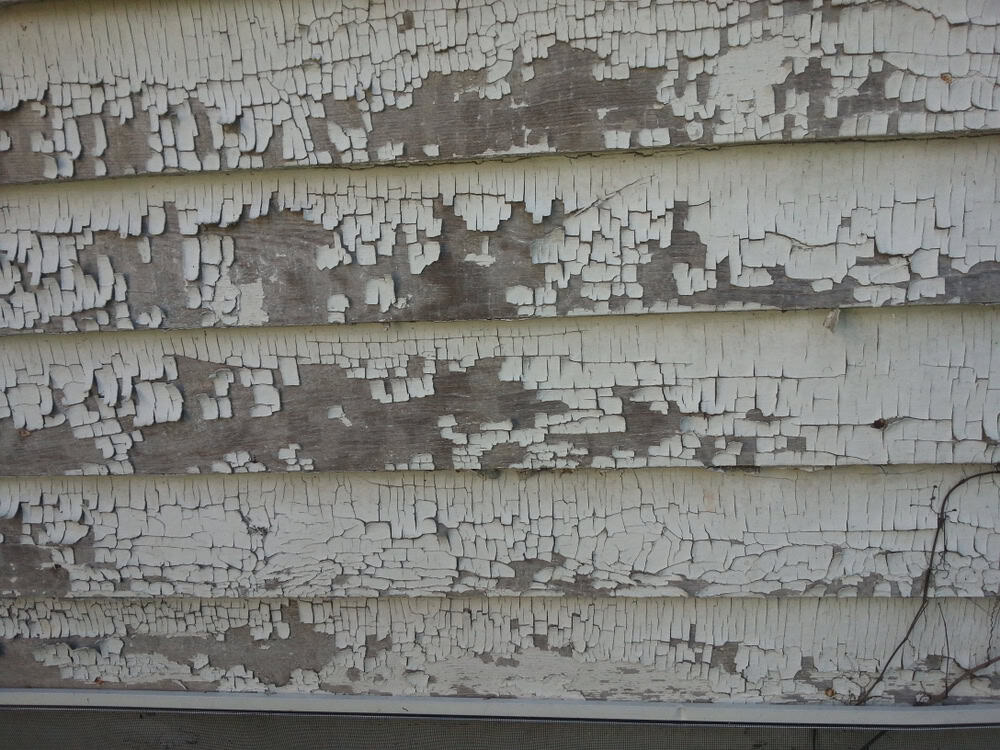Weathered wooden siding showing the passage of time with peeling paint.