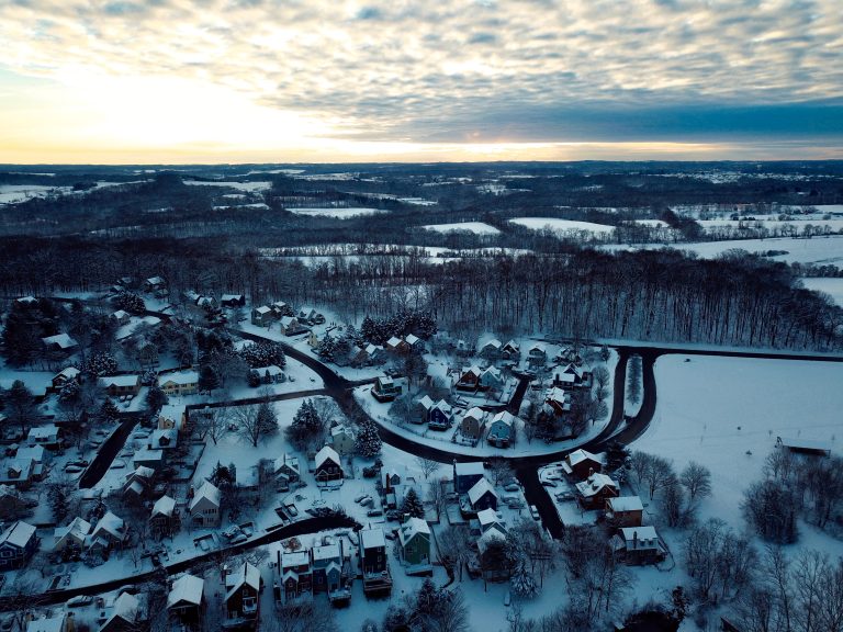 New Market, MD A serene winter morning blankets a quaint village in a fresh coat of snow, as the first light of dawn breaks through the horizon.