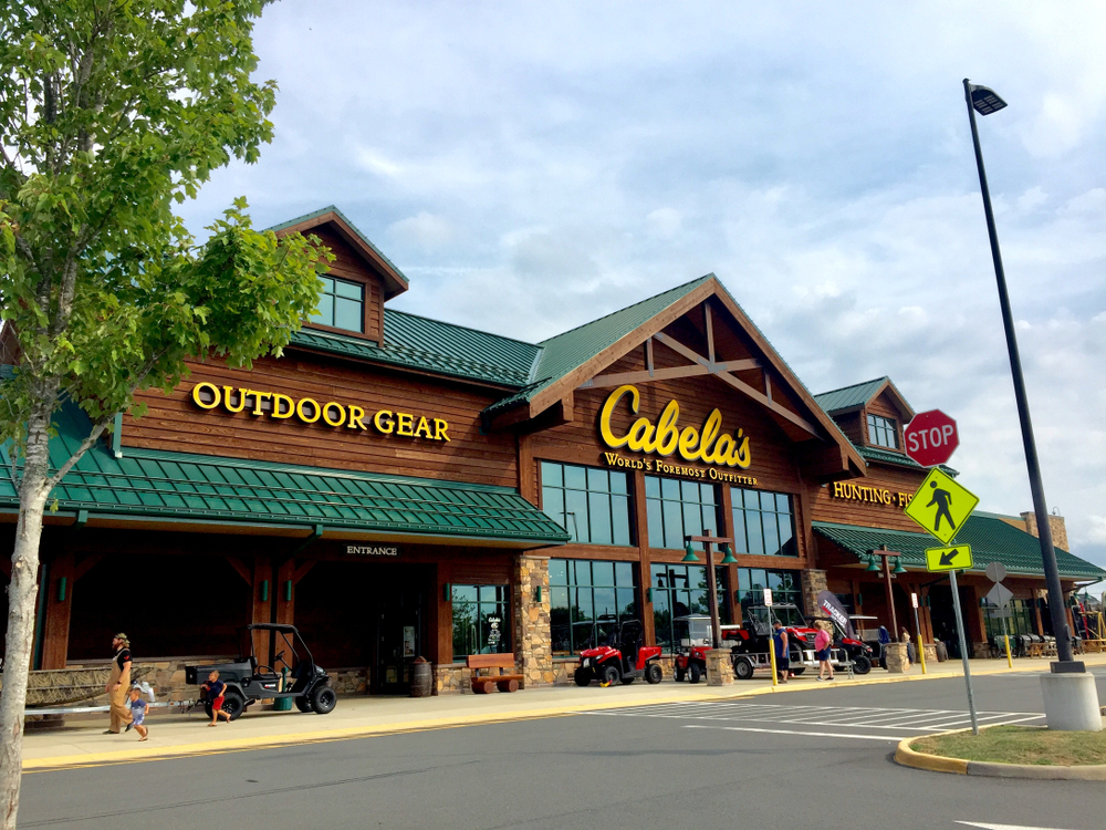 Cabela's outdoor gear store and entrance, with ATVs and people outside on a sunny day