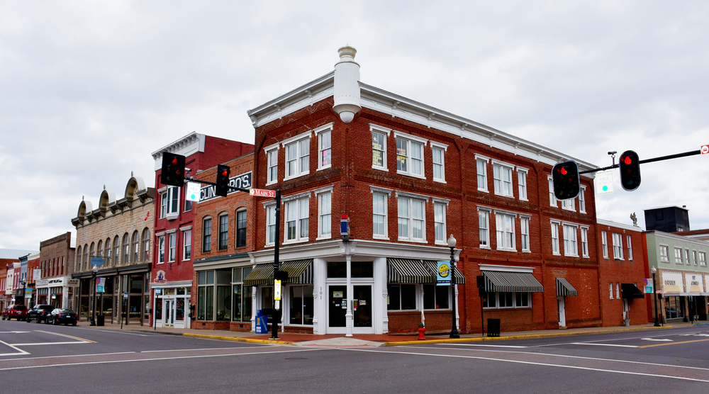 Charming historic downtown with brick buildings and quaint shops under a cloudy sky.