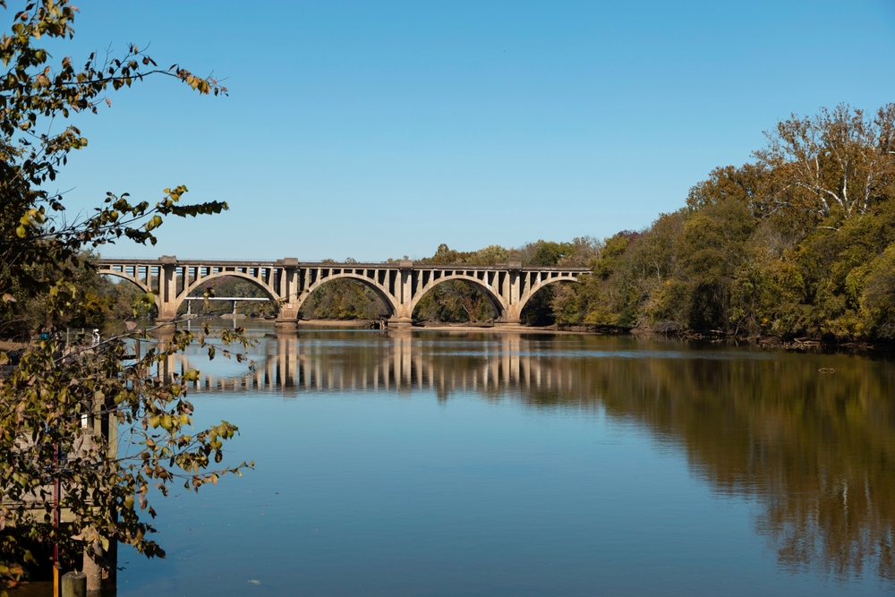 Serene reflection of a historic arched bridge over a calm river in Falmouth, VA