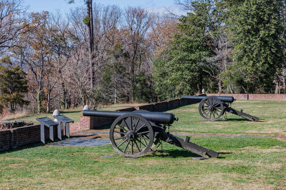 Two cannons stand guard at a historic battlefield.