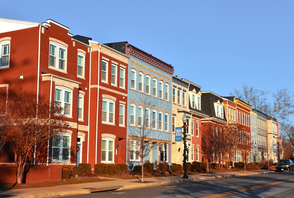 Colorful row houses along a sunny urban street.