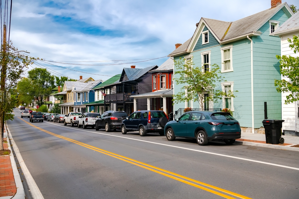 Charming street in a picturesque neighborhood featuring colorful historic homes lined up under a clear blue sky.