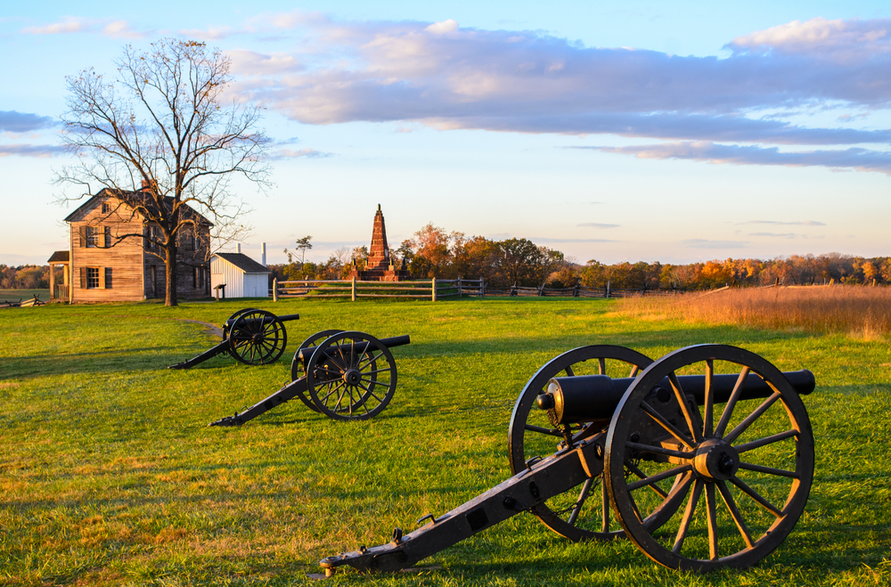 Historic battlefield with cannons at sunrise.