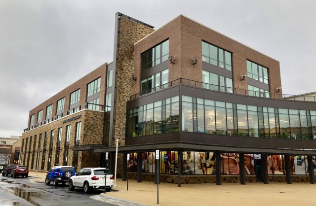 Modern office building with large windows and a brick facade.