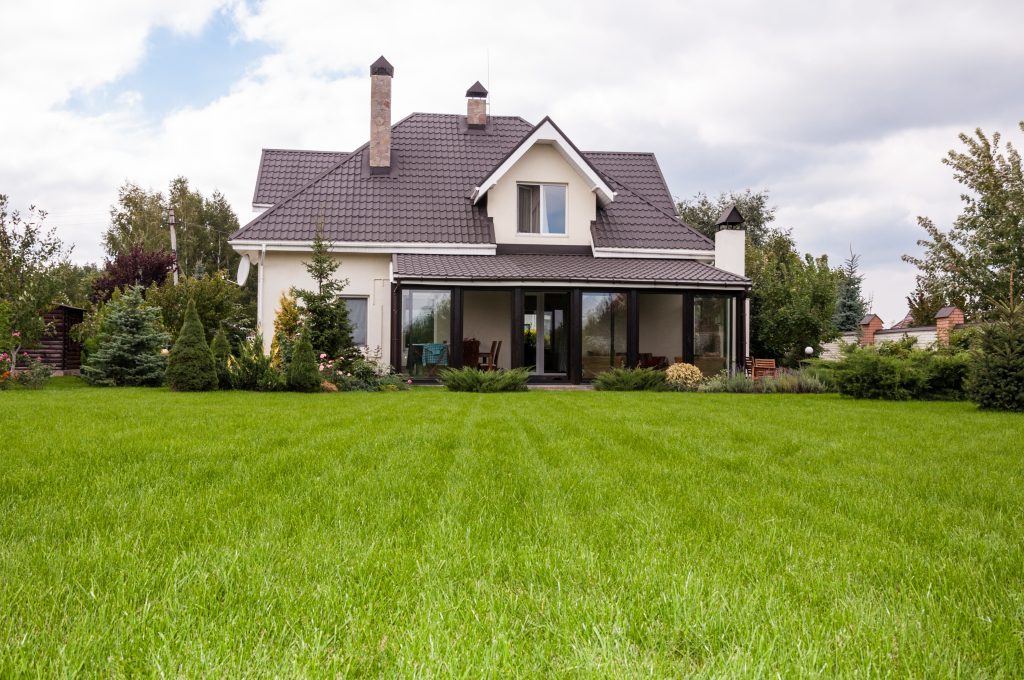 A tranquil countryside home with a lush green lawn and cozy porch.