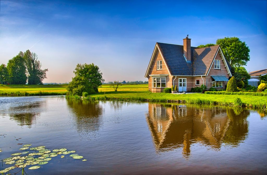 Idyllic riverside retreat amidst verdant fields and serene waters.