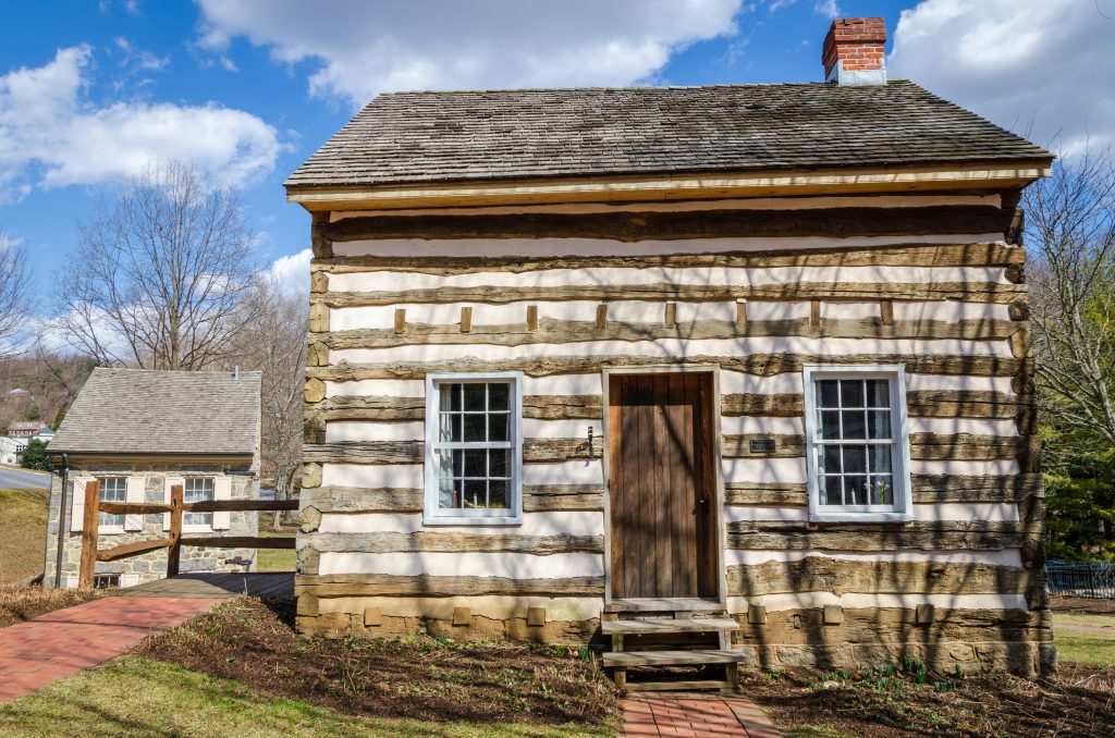 Quaint log cabin basking in the peacefulness of a sunny day.