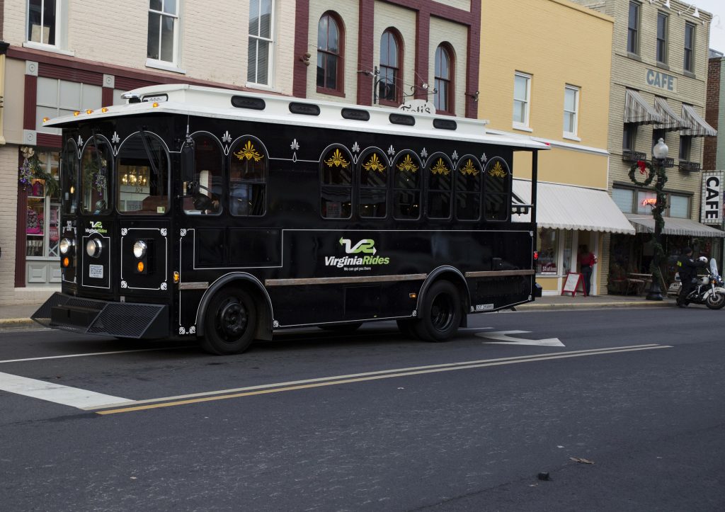 Historic downtown charm with a modern twist: Virginia Rides trolley in front of classic cafés.