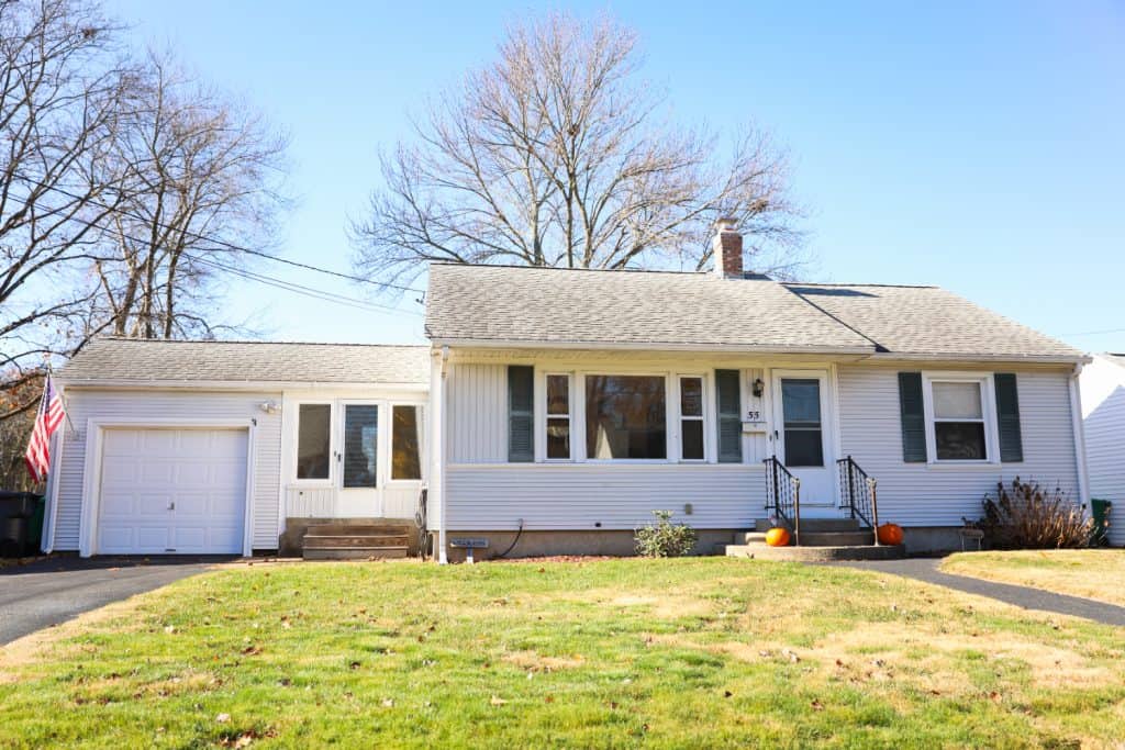Charming white suburban home with fall curb appeal, ready for new memories.