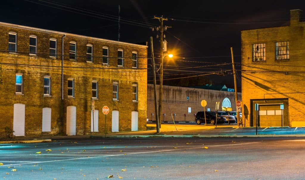 Quiet city street illuminated by streetlights, capturing the stillness of night.