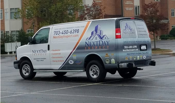 "NextDay Inspect's service van parked in a wet lot, showcasing their home inspection business with professional vehicle graphics and contact information"