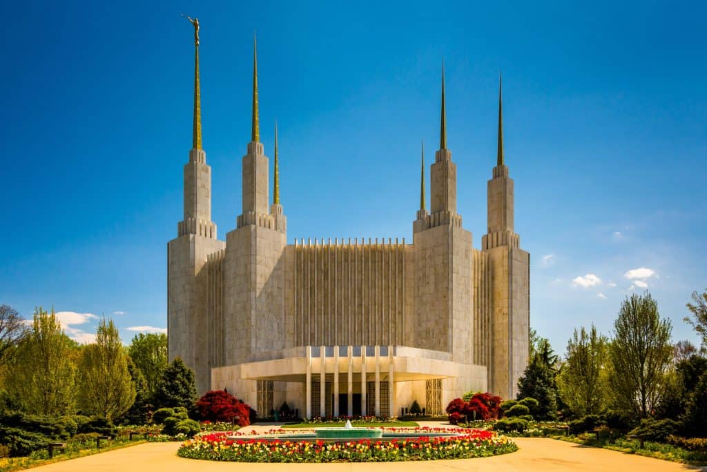 Washington DC Temple of The Church of Jesus Christ of Latter-day Saints, with its distinctive modernist spires and spring tulips blooming in the foreground garden.