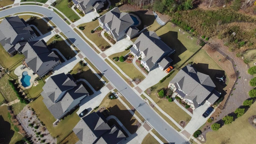 A picturesque suburban neighborhood captured from above—manicured lawns, elegant homes, and winding streets create a serene residential retreat.