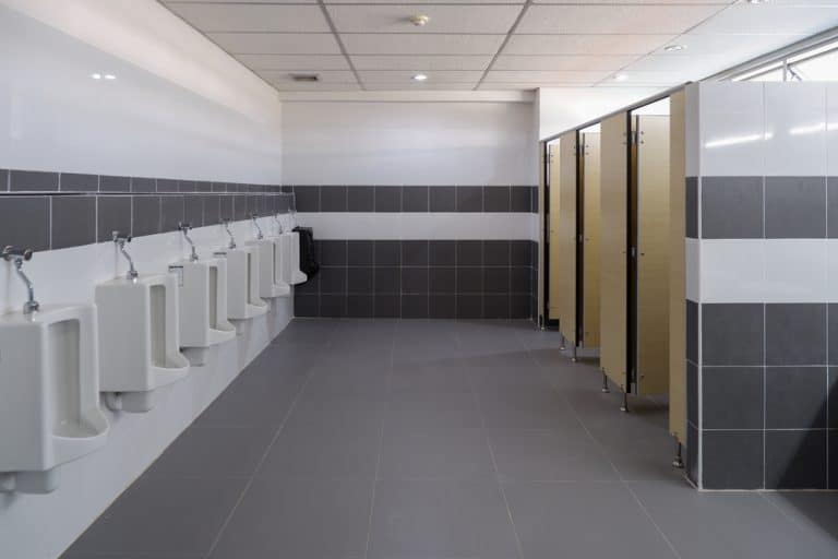 A modern and clean public restroom with urinals and private stalls.